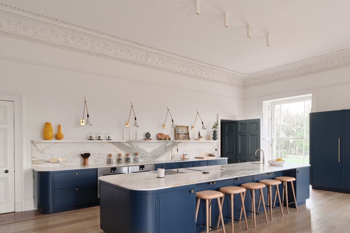 An elegant design painted in a navy colour, with a large island with preparation sink, boiling-water tap, and hob.