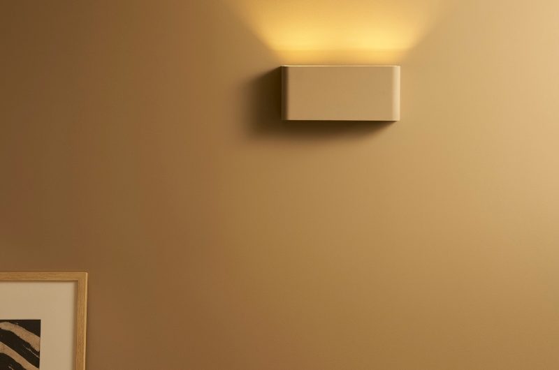 A neutral scheme with a painted wall and a matching wall light.