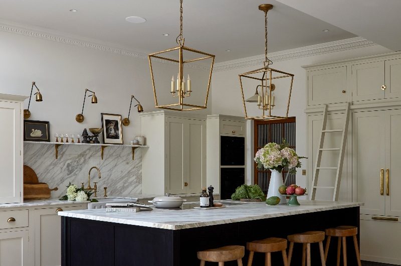 Victorian home with a classic kitchen with a central island, statement lighting and marble surfaces.