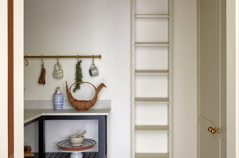 A walk-in pantry with classic cabinetry, a larder and open shelf storage.