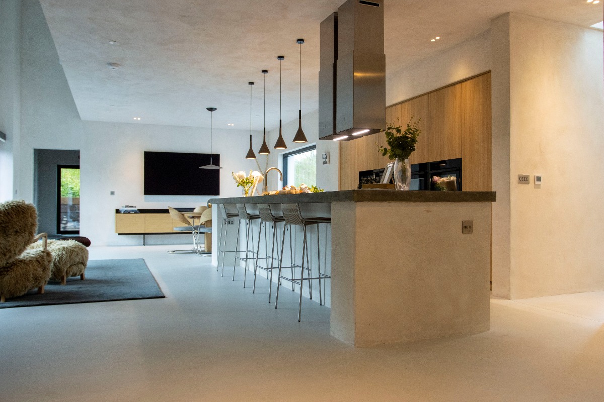 A modern kitchen with handleless wood cabinetry, built-in appliances and a spacious island with seating.