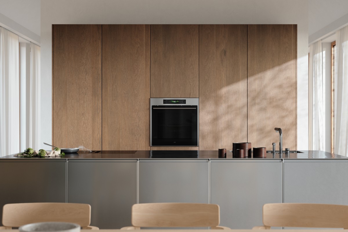 A sleek wood and stainless steel kitchen with a built-in combi oven, with a hob, sink and tap on the island.