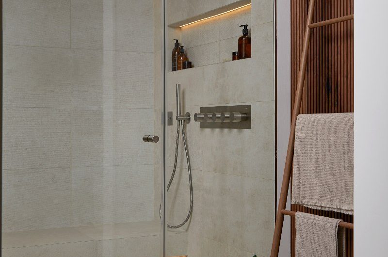 A bathroom design with shower zone and a ladder for towels.