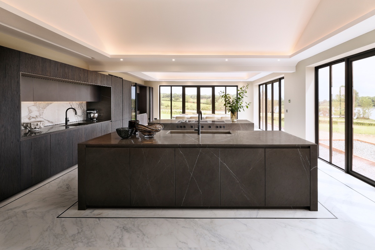 Grand kitchen design with modern wood cabinetry, and stone clad islands, and expansive glazing enjoying garden views.