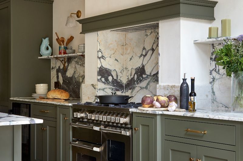 A cooking zone with a range cooker, statement work surfaces, a concealed extractor and Shaker cabinet fronts.
