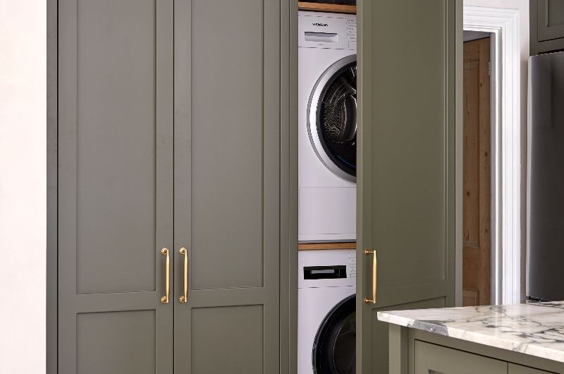 Laundry appliances concealed behind classic cabinetry.