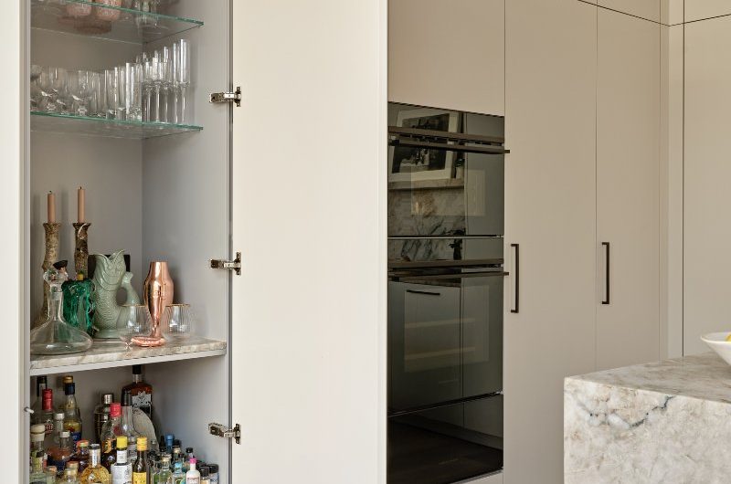 A bar area next to a run of storage and built-in appliances.