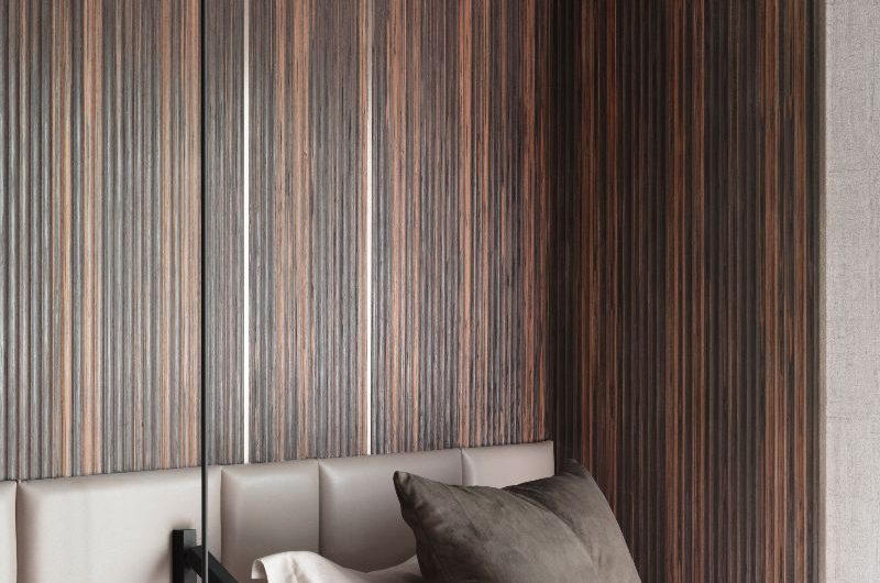Bedroom design with wood wall panelling, a leather headboard, and neutral linen.