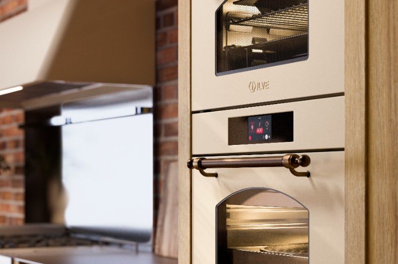Wood cabinetry with white built-in cooking appliances with a retro look.