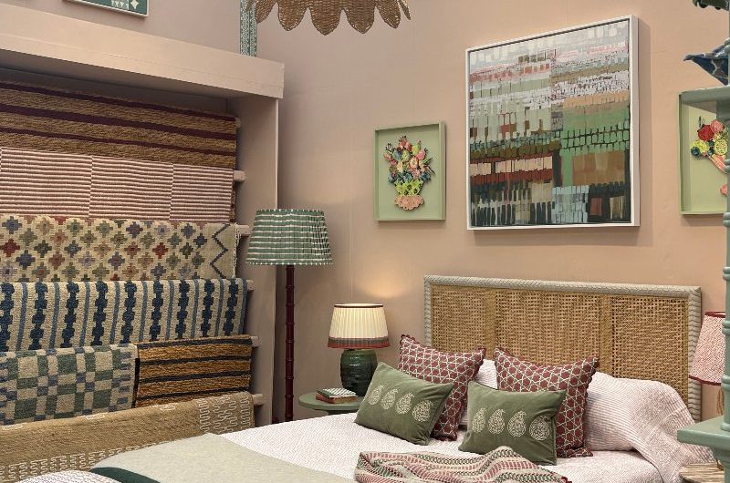 A bedroom stand at Decorex 2025 with a mix of patterned soft furnishings.