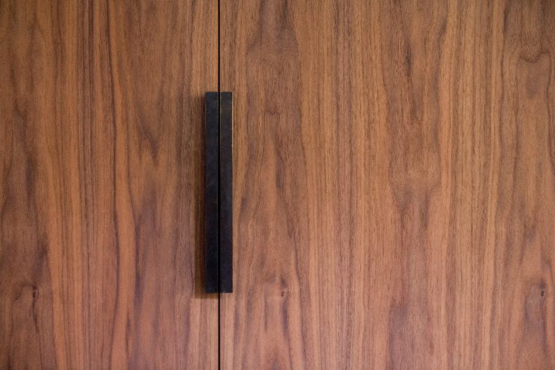 Walnut veneer cabinets with sleek black handles.