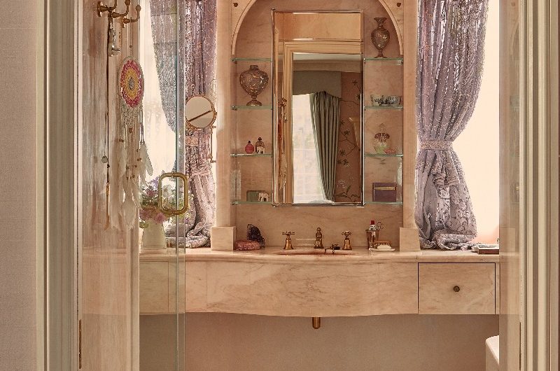 Glamorous bespoke vanity unit clad in pink marble with drawers, and carved floral motifs with an Art Deco mirror in Kate Moss' bathroom.