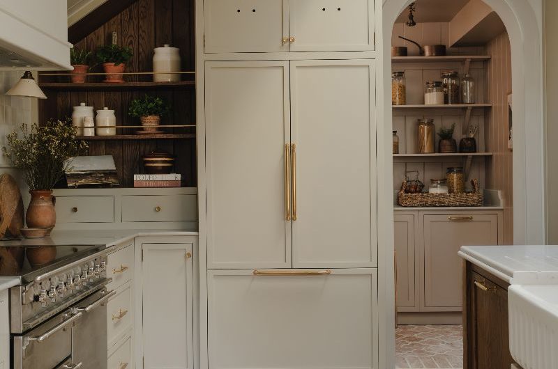 A kitchen design with classic cabinetry and a walk-in pantry with an arched entryway.