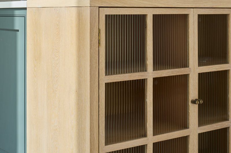 Closeup at a wood display cabinet with fluted glass.