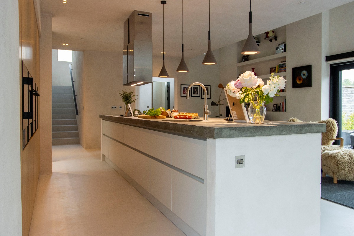 A calming space with a central island with handleless units and ambient lighting.