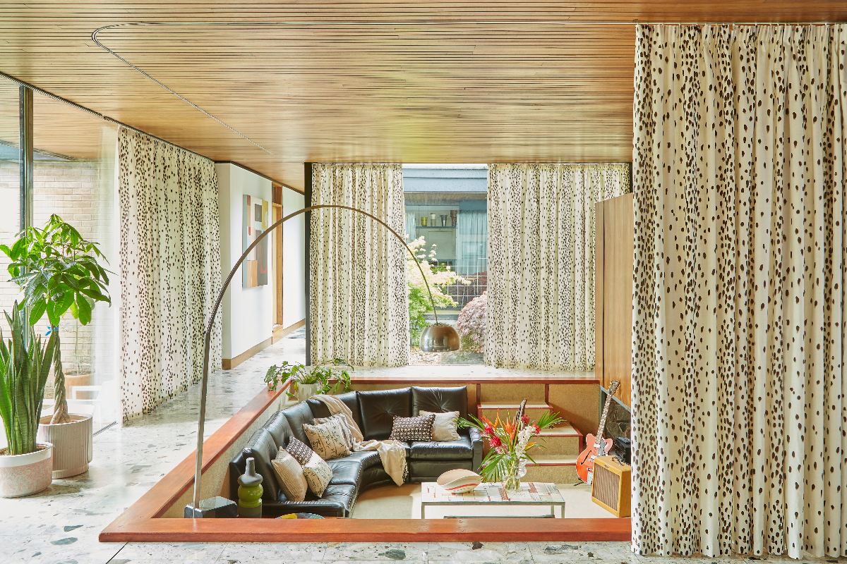 70s style living room with wood ceiling, patterned furnishings, and a conversation pit.