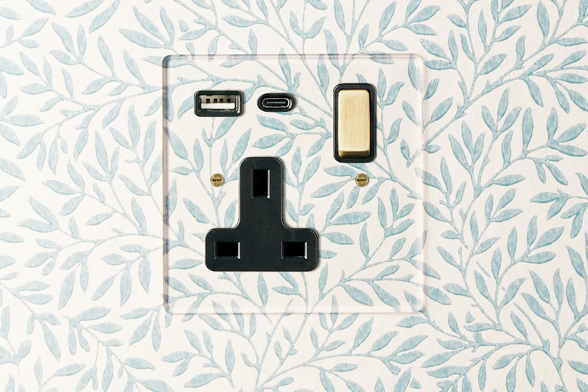 Wall drenched in wallpaper with a matching power socket.