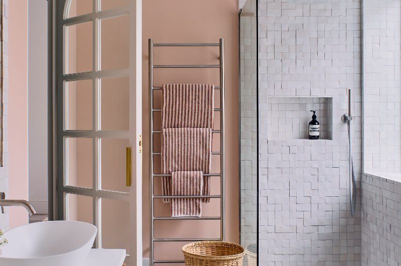 A pink bathroom design with a shower zone with zellige tiles and a glass screen, a freestanding tub, and a wood vanity zone.