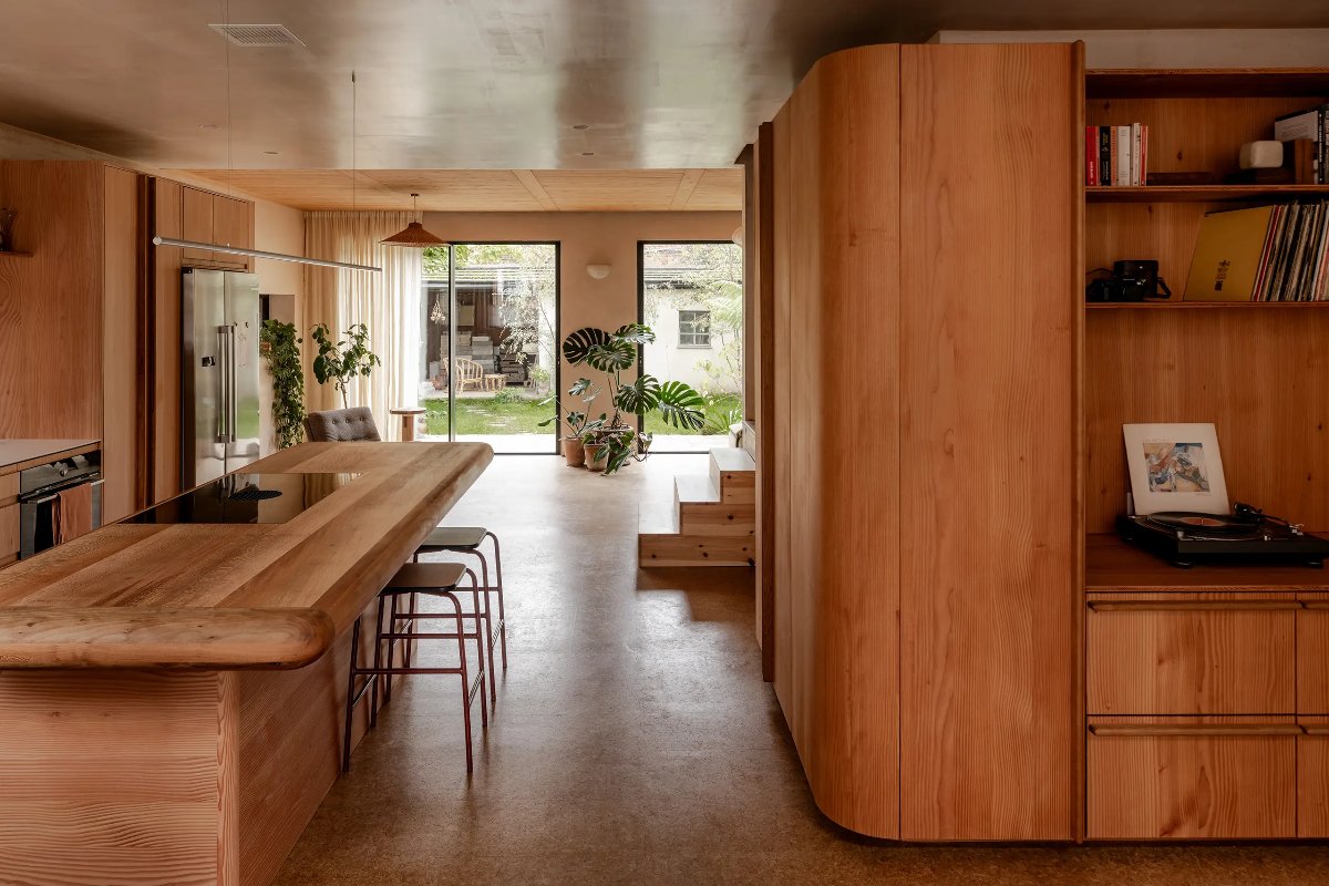 Wood drenched kitchen with a matching island with extraction hob and breakfast bar with stools.