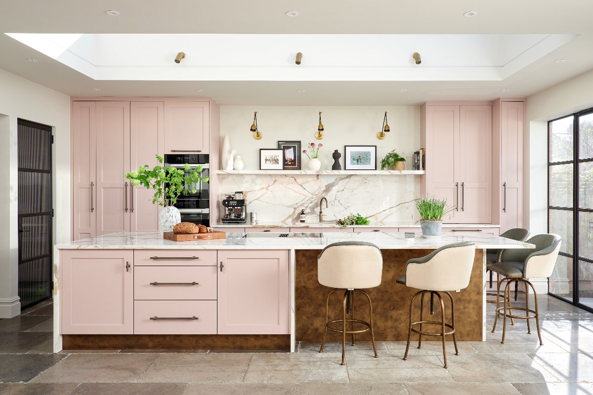 A light scheme with tall floor-to-ceiling classic cabinetry and a central island with storage, seating a, metallic base and veiny worktops.