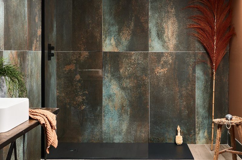 A modern bathroom with shower tiles in a slate effect, black shower tray, wood-effect flooring, and minimalist decor.