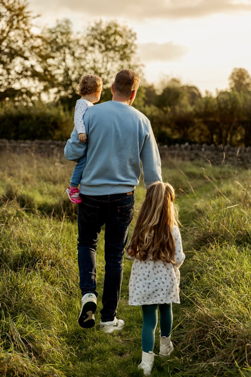 Georgina's husband and daughters in a field.