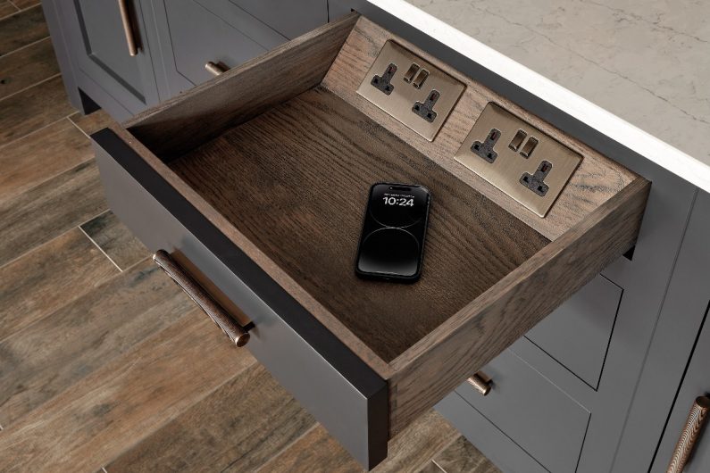 A drawer with wood interiors and built-in power plugs.