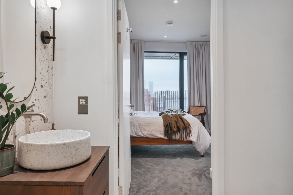 A bathroom with adjoining ensuite with neutral furnishings.