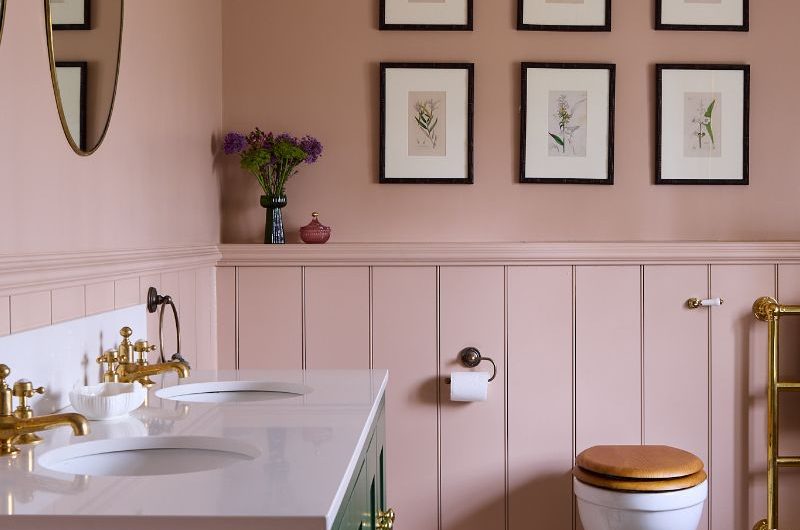 A charming bathroom design with pink wall panelling, a green double vanity and classic sanitaryware.