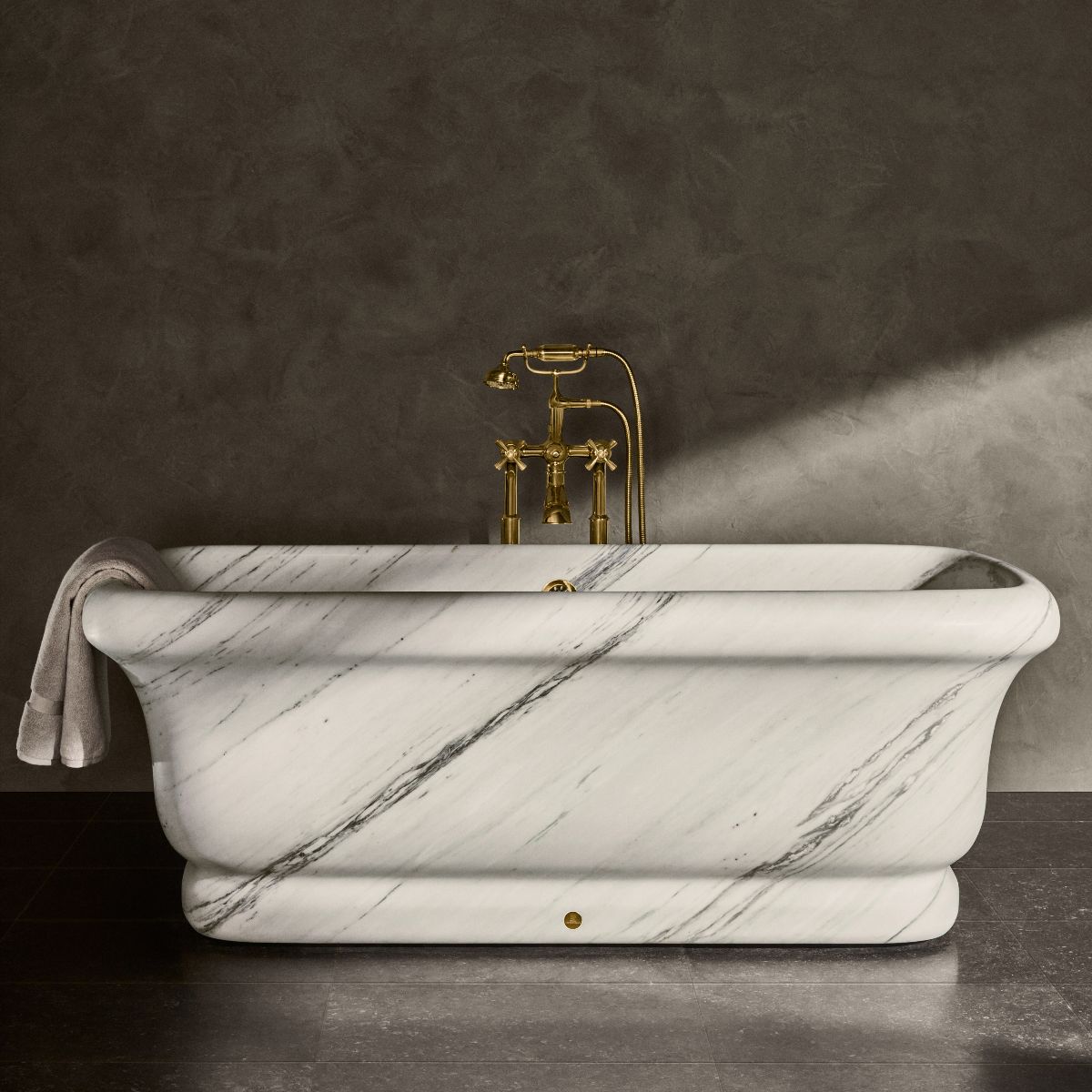A marble bath with gold brassware.