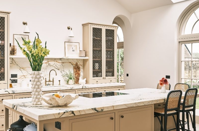 A modern, elegant design with mesh countertop cupboards, marble surfaces, and a central island with seating.