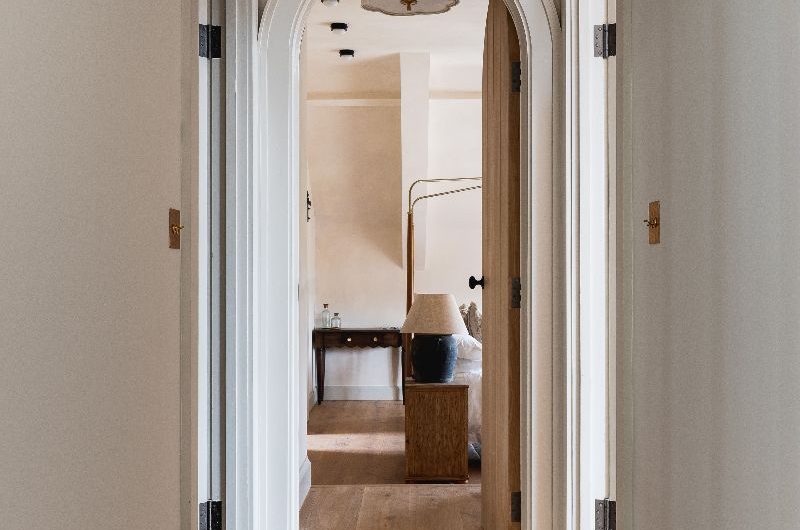 Hallway with arched entryways and wood flooring.