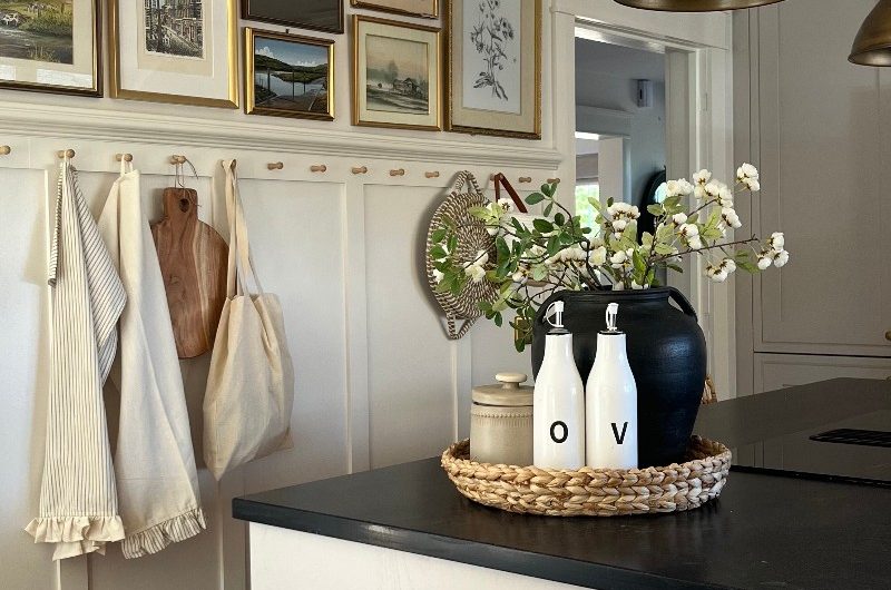 Classic kitchen project with a panelled wall, wall gallery, and a central island with dark worktop and hob.
