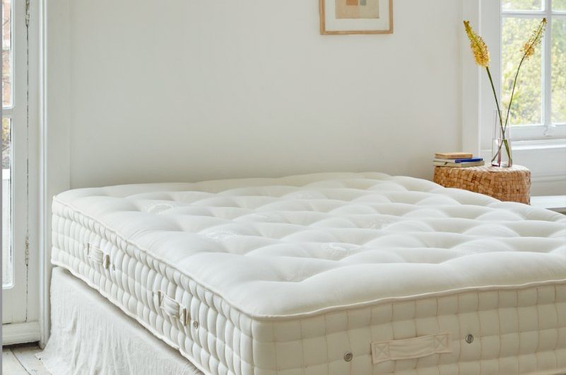 A rustic bedroom design with an exposed wool mattress and natural decor.