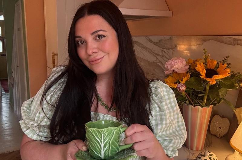 Renovator posing in her kitchen with a lettuce mug and saucer.