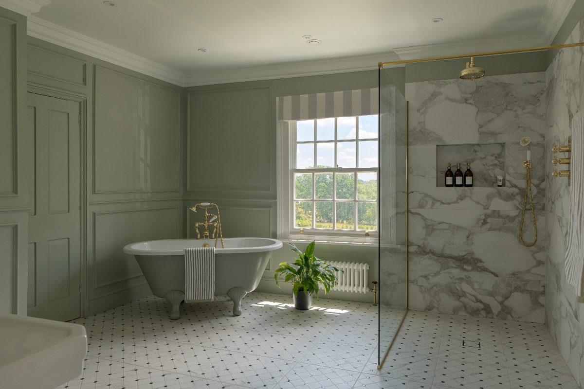 A glamorous bathroom with light green wall paint, matching freestanding tub, and a walk-in shower with marbled surfaces and gold hardware and brassware.