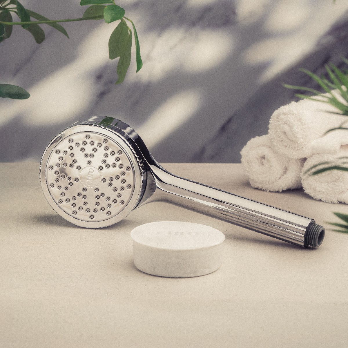 A filtered water shower head in chrome in a spa bathroom.