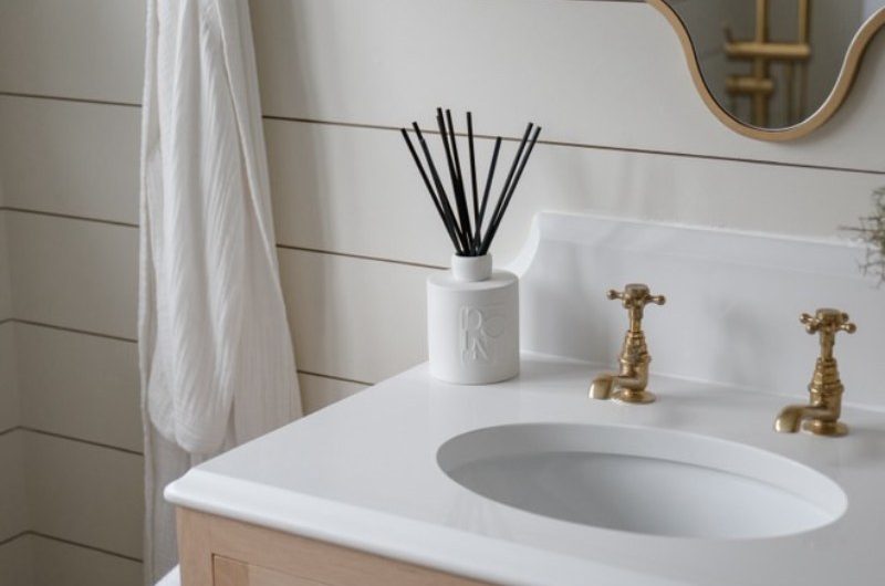 A classic bathroom with a wood vanity and a white diffuser.