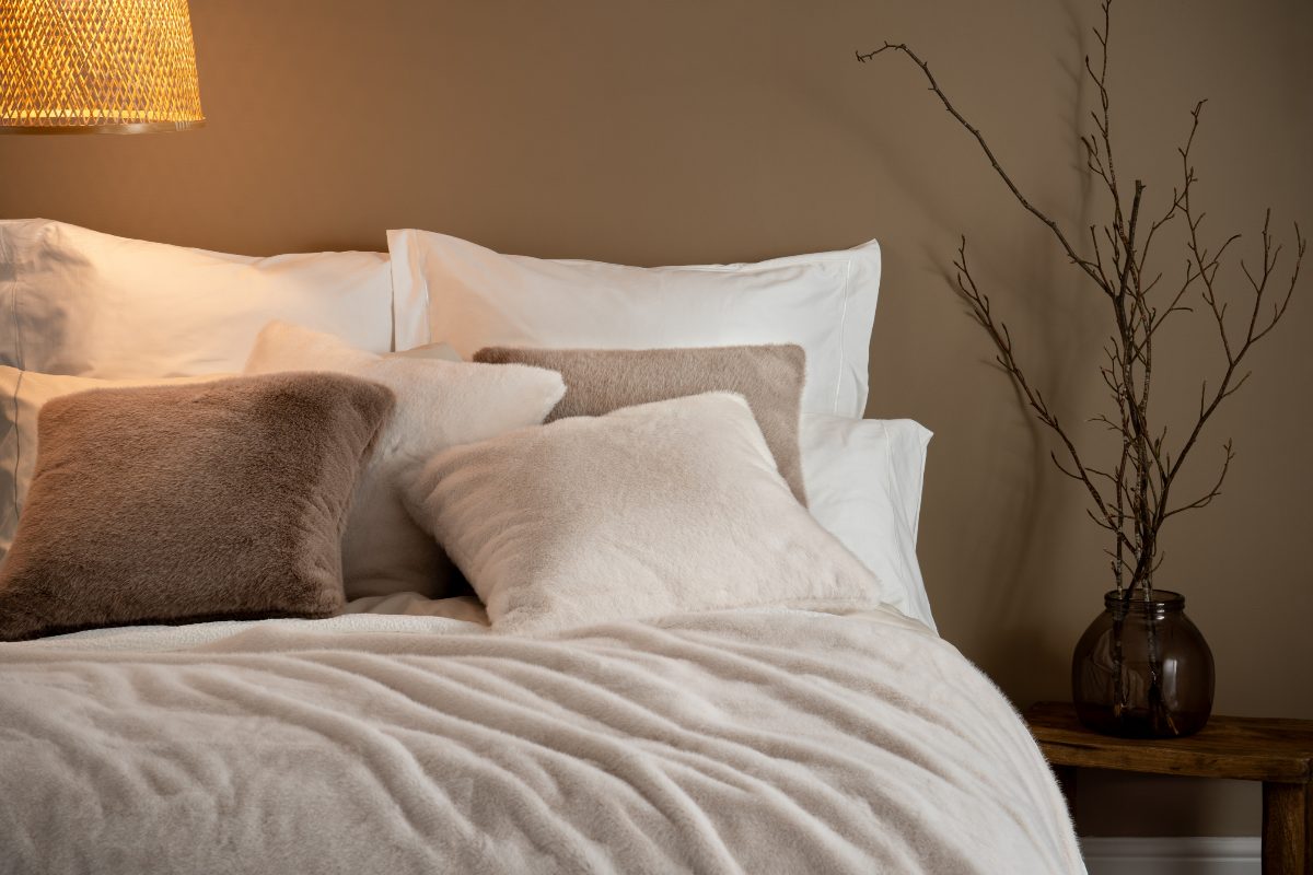 A calm bedroom design with faux fur furnishings in neutral shades.