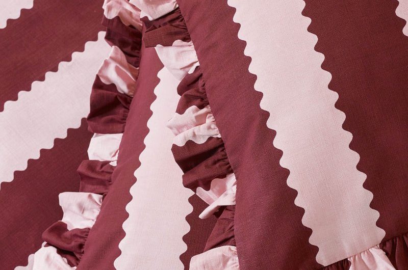 Closeup at candy cane striped bedding in pink and burgundy.