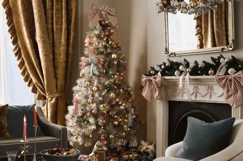 A living room with a fireplace and regal seating solutions, curtains, and glamorous decor.