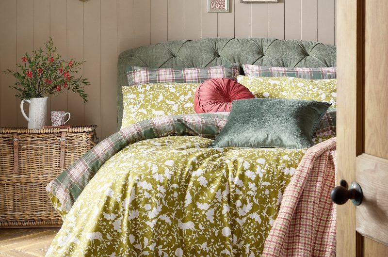 A winter-inspired sleep space with green nature patterned linen and accent cushions.