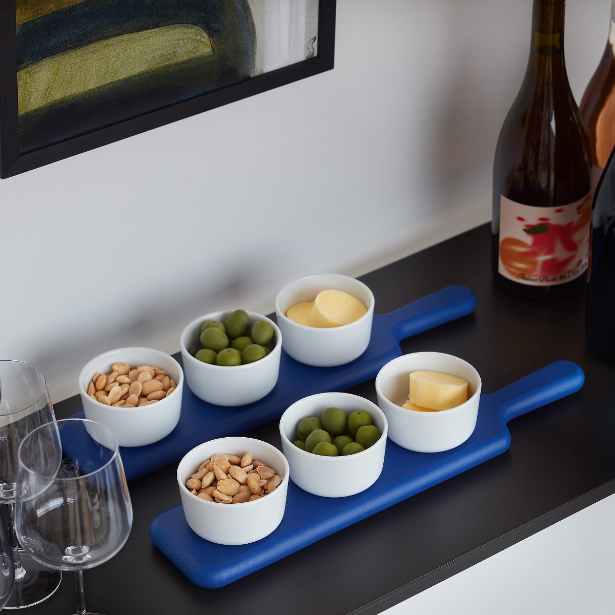 A minimalist scheme with blue nibble boards and wine glasses.
