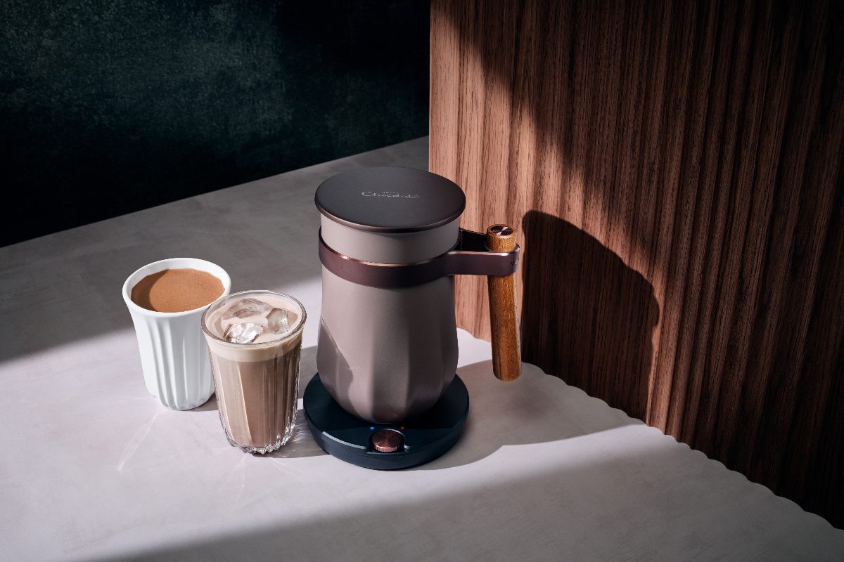 A hot chocolate machine in a wood and stone kitchen.