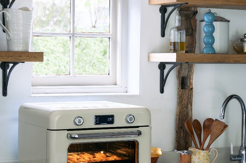 A kitchen design with a countertop oven, wood tray, and rustic decor.