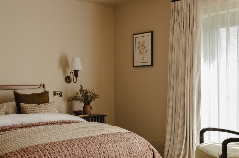 A neutral bedroom with layered textures and a cosy carpet.