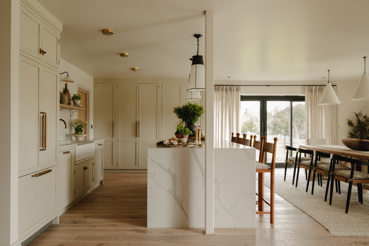 A neutral kitchen in the countryside with classic Shaker cabinets, a marble-effect-clad island and a spacious dining zone.