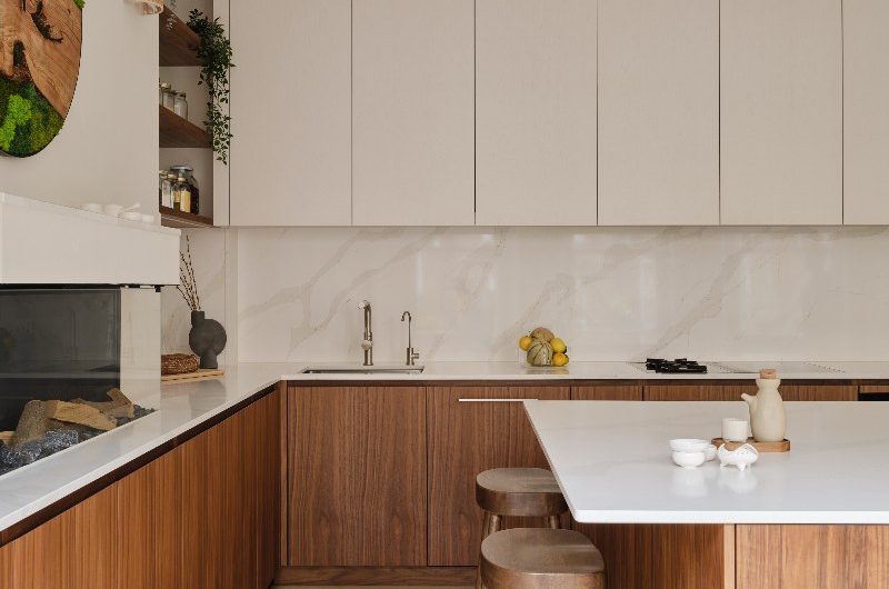 A walnut kitchen with a cooking run and a faux fireplace and central island with seating and a breakfast bar.