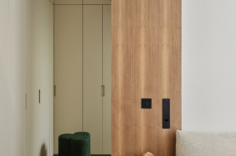 A calm bedroom design with fitted wardrobes and wood finishes and furniture.